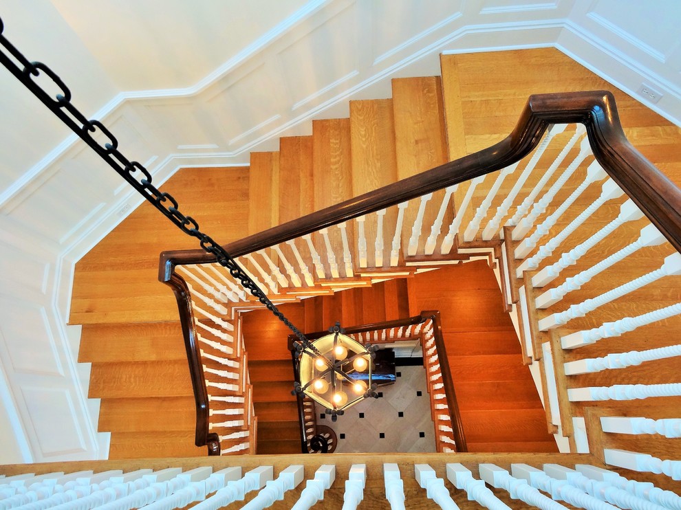 Idée de décoration pour un très grand escalier hélicoïdal tradition avec des marches en bois.