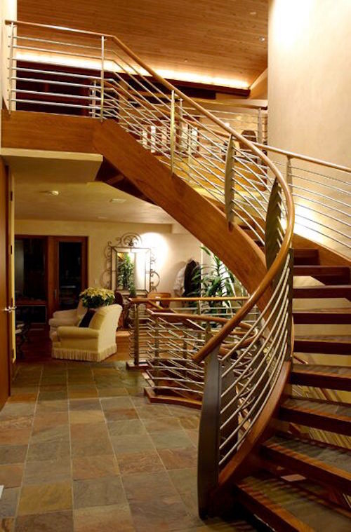 Свежая идея для дизайна: большая изогнутая лестница в стиле модернизм с бетонными ступенями и металлическими перилами без подступенок - отличное фото интерьера