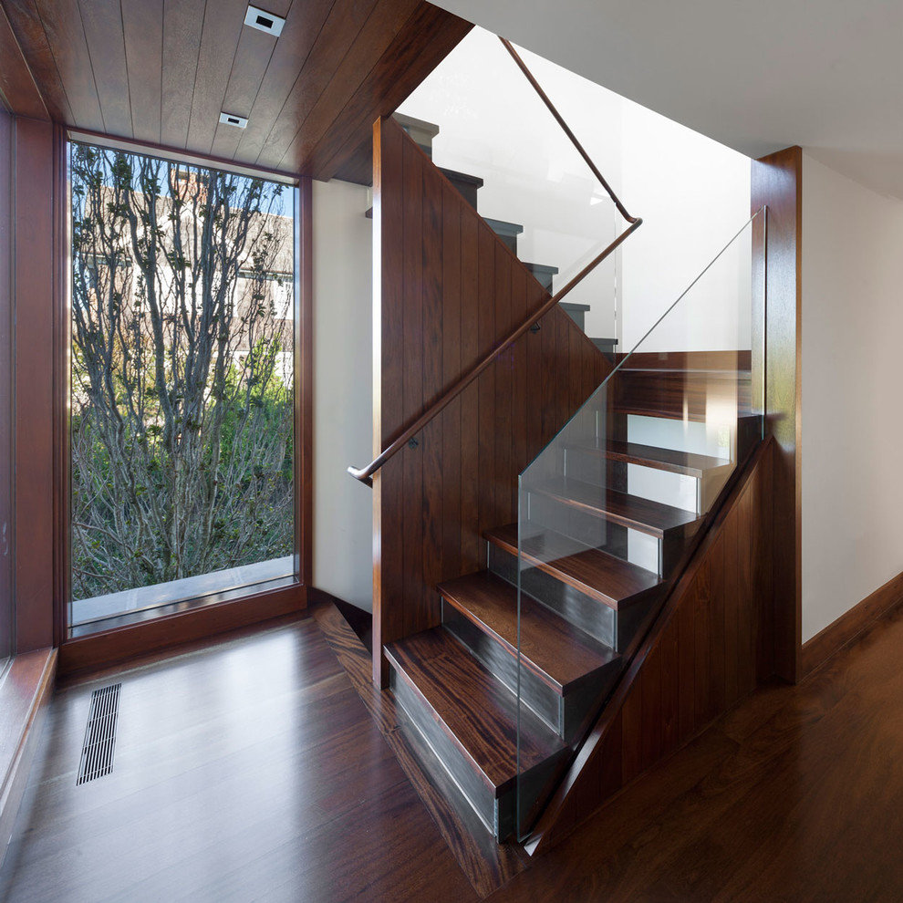 Стильный дизайн: п-образная лестница в современном стиле с деревянными ступенями и стеклянными подступенками - последний тренд