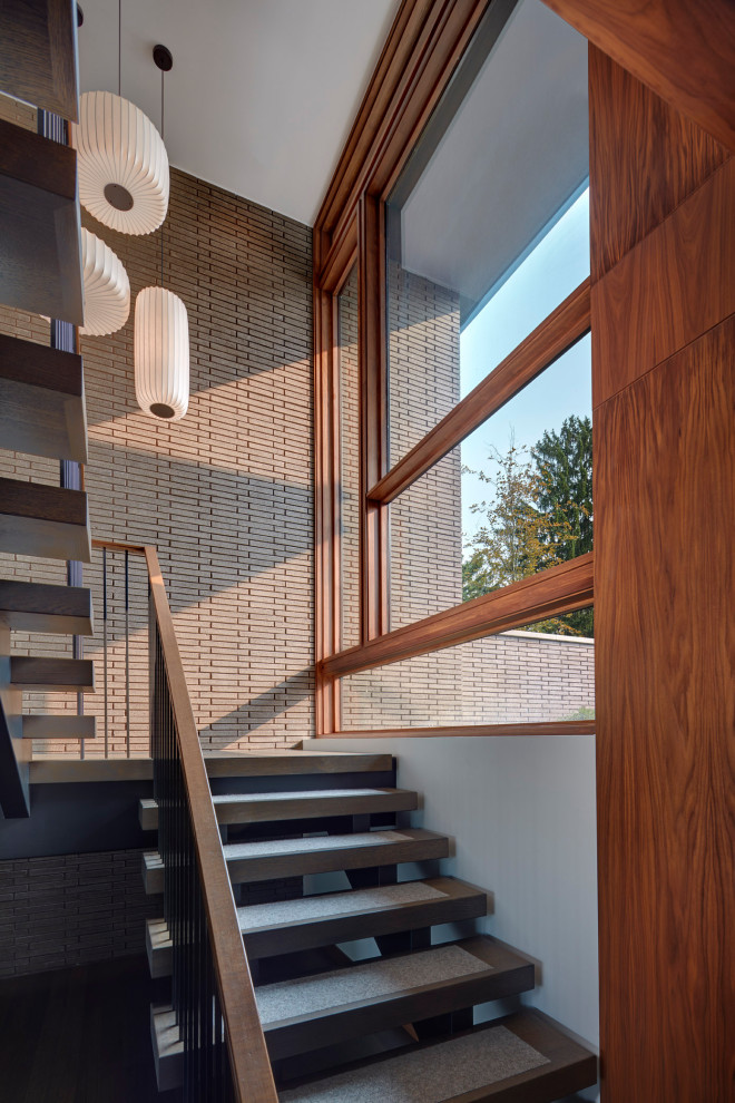 Diseño de escalera contemporánea sin contrahuella con barandilla de varios materiales
