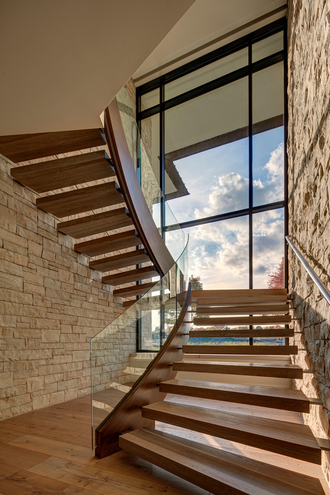 Ejemplo de escalera en U actual sin contrahuella con escalones de madera y barandilla de vidrio