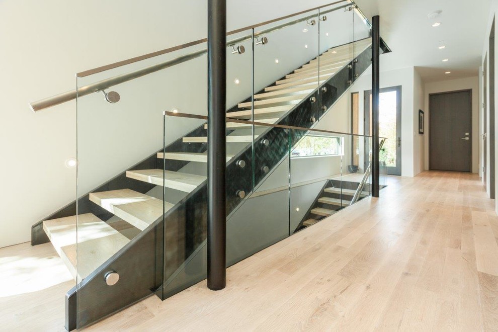 Пример оригинального дизайна: большая лестница на больцах в стиле модернизм с деревянными ступенями и металлическими перилами без подступенок