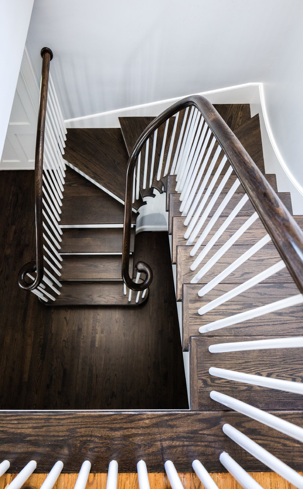 Стильный дизайн: изогнутая лестница в стиле неоклассика (современная классика) с деревянными ступенями, крашенными деревянными подступенками и деревянными перилами - последний тренд