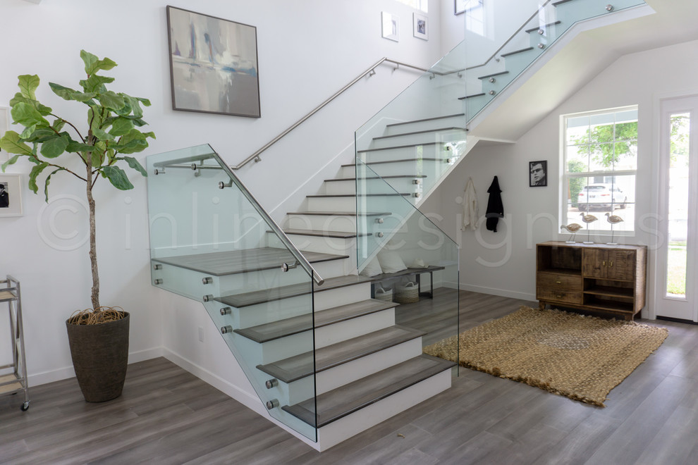 Diseño de escalera moderna de tamaño medio con contrahuellas de vidrio, barandilla de vidrio y escalones de madera
