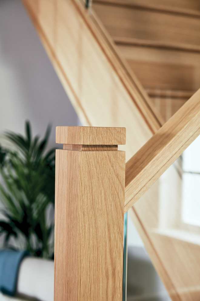 Modelo de escalera en U clásica renovada de tamaño medio con escalones de madera, contrahuellas de madera y barandilla de vidrio