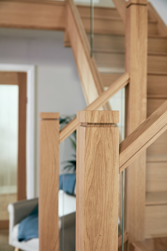 Свежая идея для дизайна: п-образная деревянная лестница среднего размера в стиле неоклассика (современная классика) с деревянными ступенями и стеклянными перилами - отличное фото интерьера