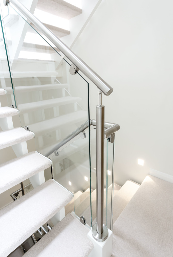 На фото: лестница среднего размера в современном стиле с ступенями с ковровым покрытием и металлическими перилами с