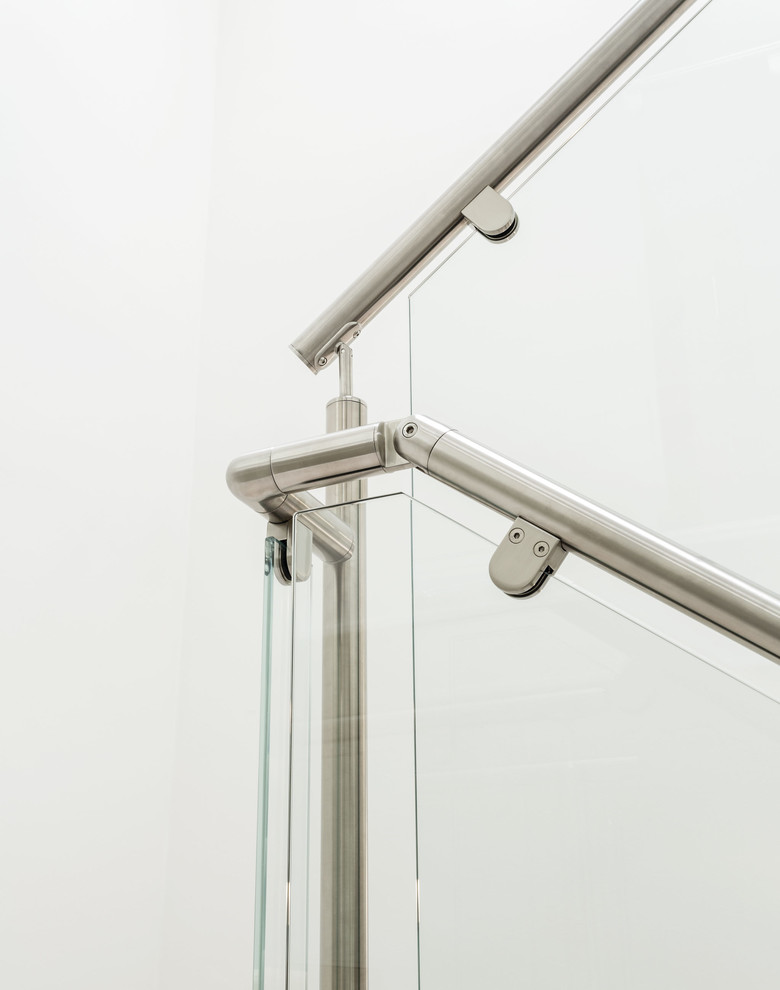 Cette image montre un escalier design de taille moyenne avec des marches en moquette et un garde-corps en métal.