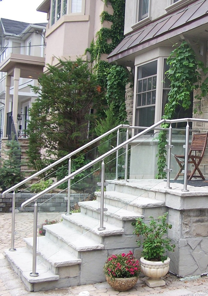 Imagen de escalera recta contemporánea de tamaño medio con escalones con baldosas, contrahuellas con baldosas y/o azulejos y barandilla de vidrio