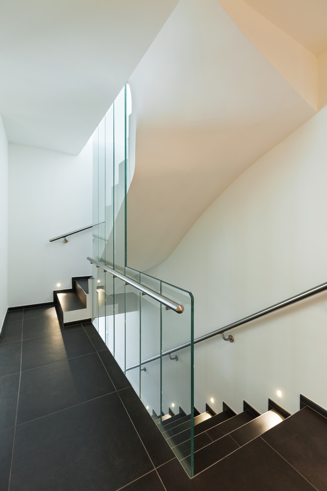 Inspiration pour un escalier carrelé droit design avec un garde-corps en verre.