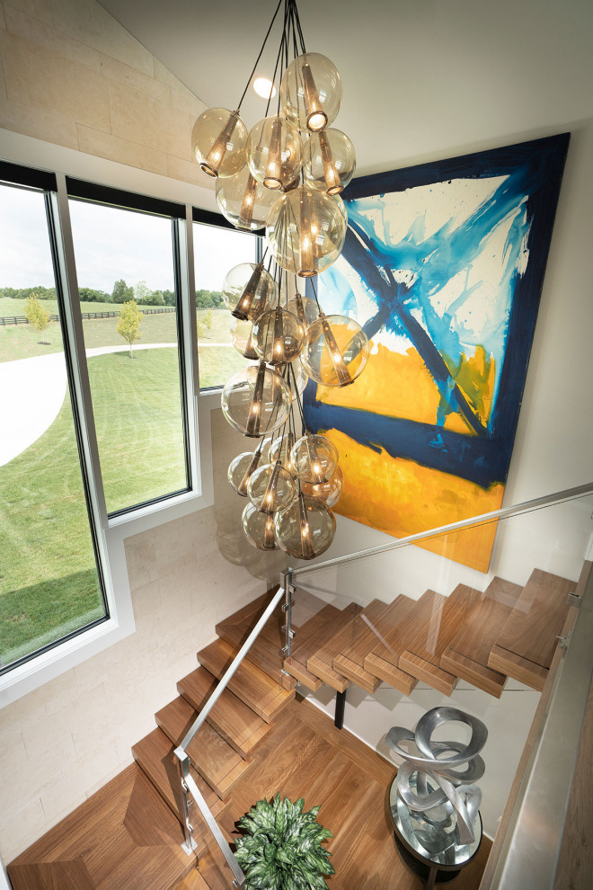 На фото: лестница на больцах, среднего размера в стиле модернизм с деревянными ступенями и перилами из смешанных материалов с