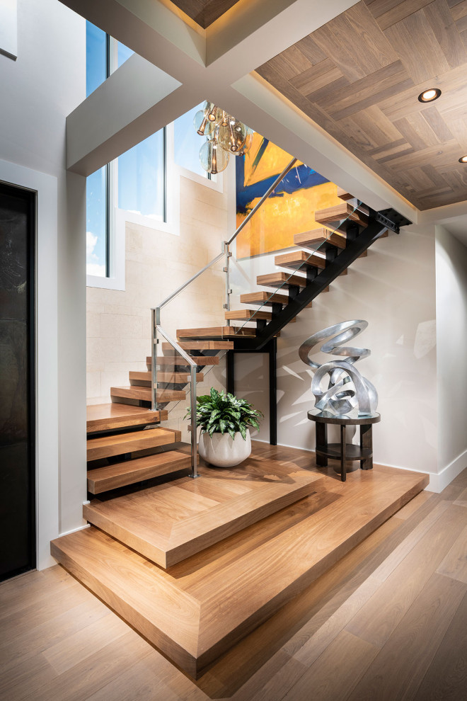 Diseño de escalera suspendida minimalista grande sin contrahuella con escalones de madera y barandilla de metal