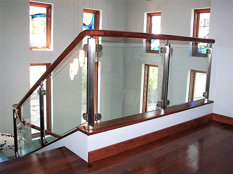 Ejemplo de escalera en L tradicional renovada grande con escalones de madera y barandilla de vidrio