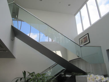 Foto de escalera suspendida contemporánea de tamaño medio con escalones de vidrio y contrahuellas de hormigón
