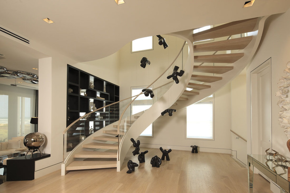 Inspiration pour un escalier sans contremarche courbe design avec des marches en bois et éclairage.
