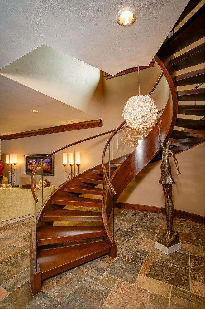 Cette image montre un escalier sans contremarche courbe design avec des marches en bois et éclairage.