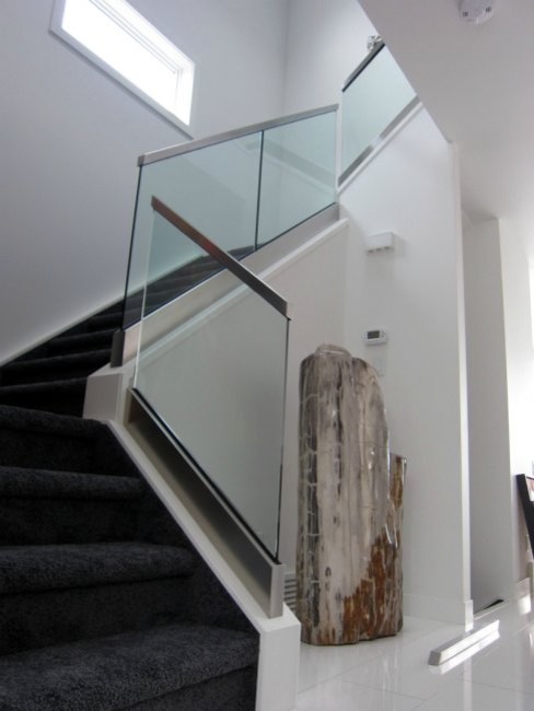 Modelo de escalera en U minimalista de tamaño medio con escalones enmoquetados, contrahuellas enmoquetadas y barandilla de vidrio