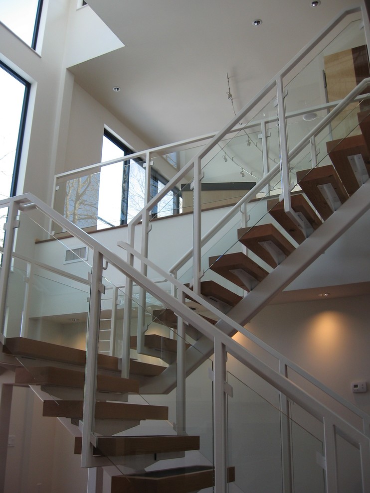 Photo of a contemporary wood floating glass railing staircase in Minneapolis with metal risers.
