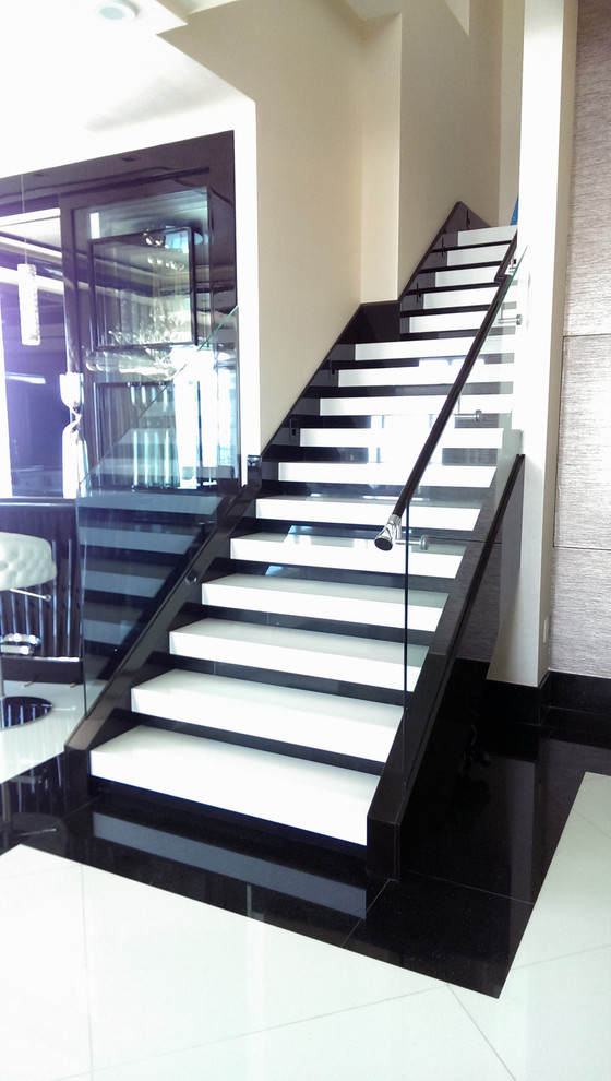 Imagen de escalera recta moderna grande sin contrahuella con barandilla de vidrio y escalones de vidrio
