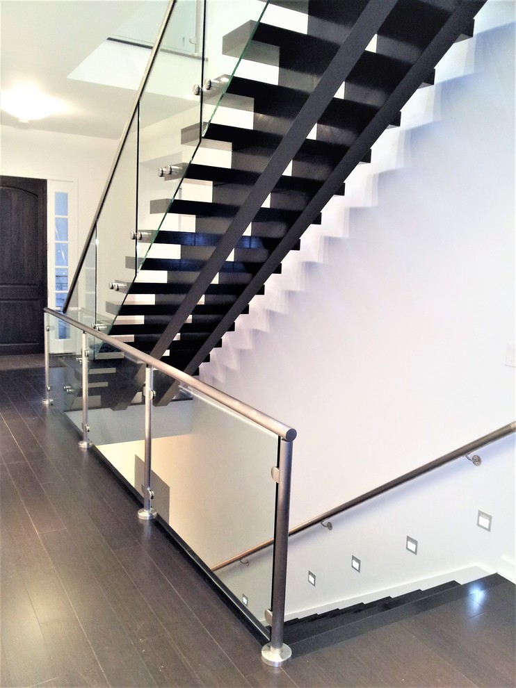 Imagen de escalera suspendida minimalista grande con escalones de madera pintada y barandilla de vidrio