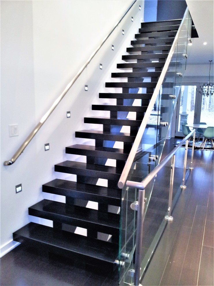 Photo of a large modern painted wood floating glass railing staircase in Indianapolis.