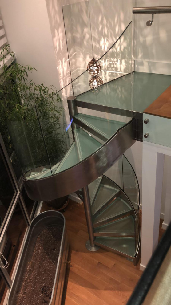 Aménagement d'un escalier sans contremarche hélicoïdal contemporain en bois de taille moyenne avec des marches en verre et un garde-corps en verre.