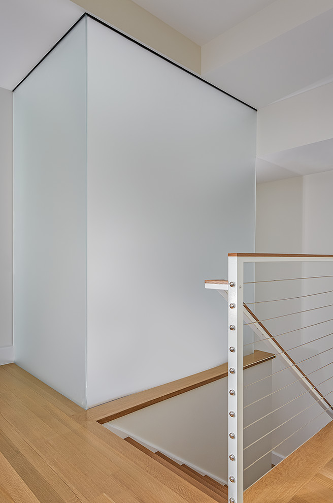Идея дизайна: большая п-образная металлическая лестница в стиле модернизм с стеклянными ступенями и деревянными перилами