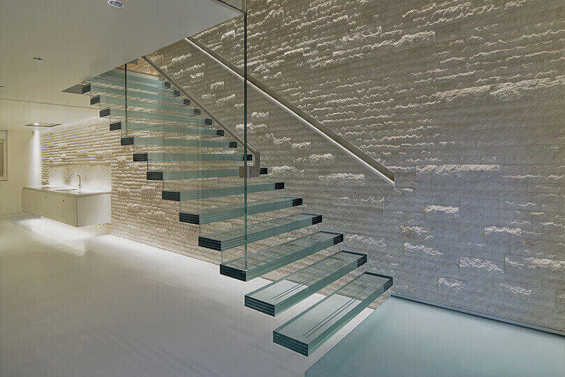 На фото: лестница на больцах, среднего размера в стиле модернизм с стеклянными ступенями и стеклянными перилами без подступенок с