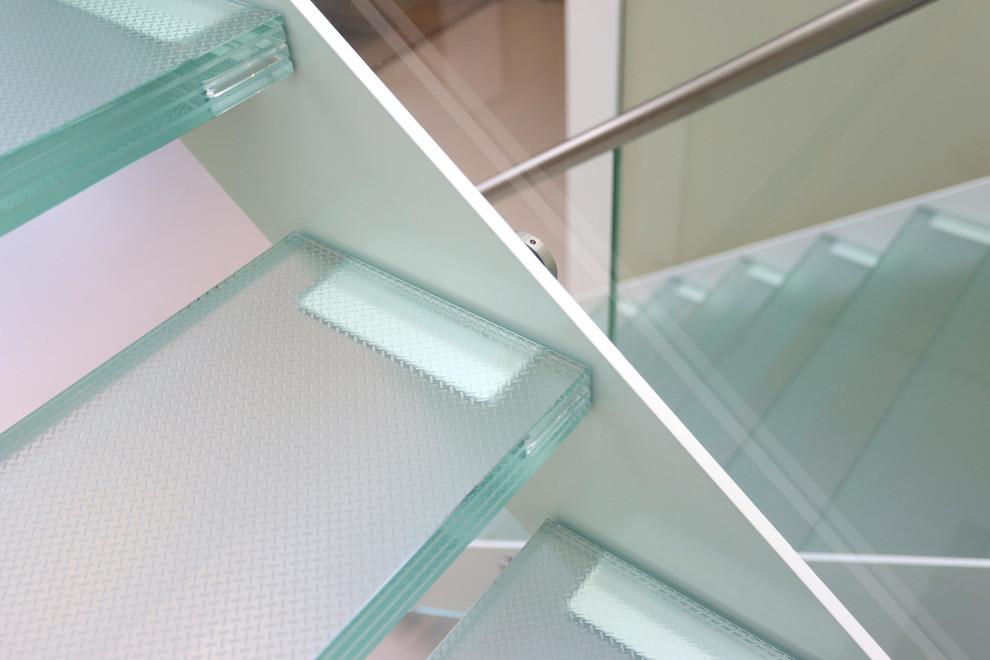Ejemplo de escalera en U minimalista de tamaño medio sin contrahuella con escalones de vidrio y barandilla de vidrio