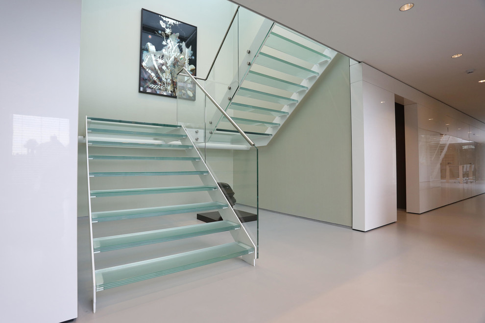 Ejemplo de escalera suspendida minimalista de tamaño medio sin contrahuella con escalones de vidrio y barandilla de vidrio