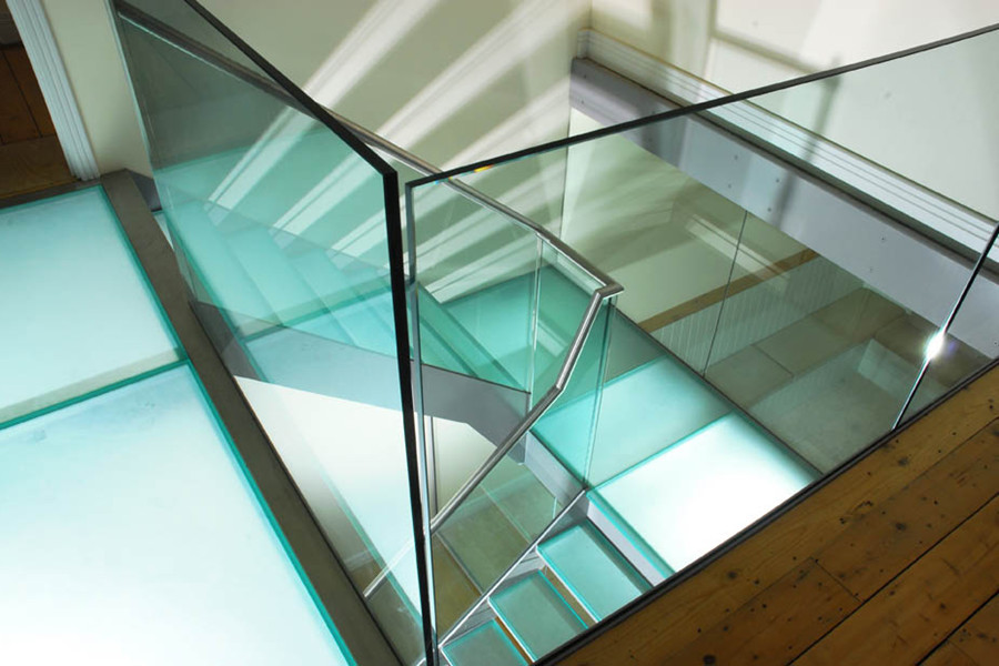Стильный дизайн: большая п-образная лестница в современном стиле с стеклянными ступенями и стеклянными перилами без подступенок - последний тренд