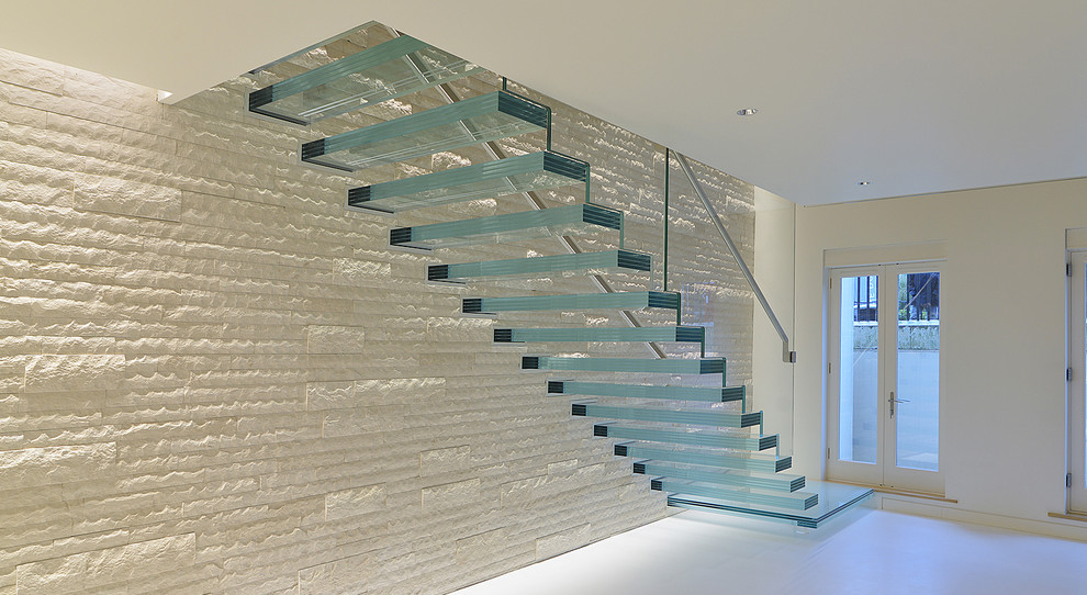 Inspiration pour un escalier sans contremarche flottant minimaliste de taille moyenne avec des marches en verre et un garde-corps en verre.