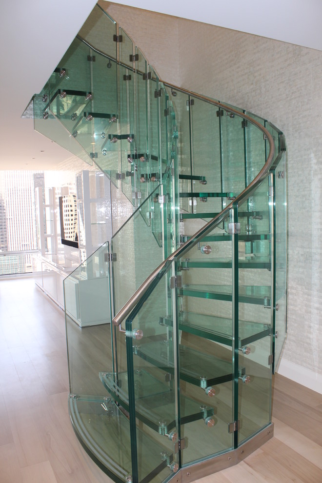 Aménagement d'un escalier sans contremarche courbe contemporain avec des marches en verre.