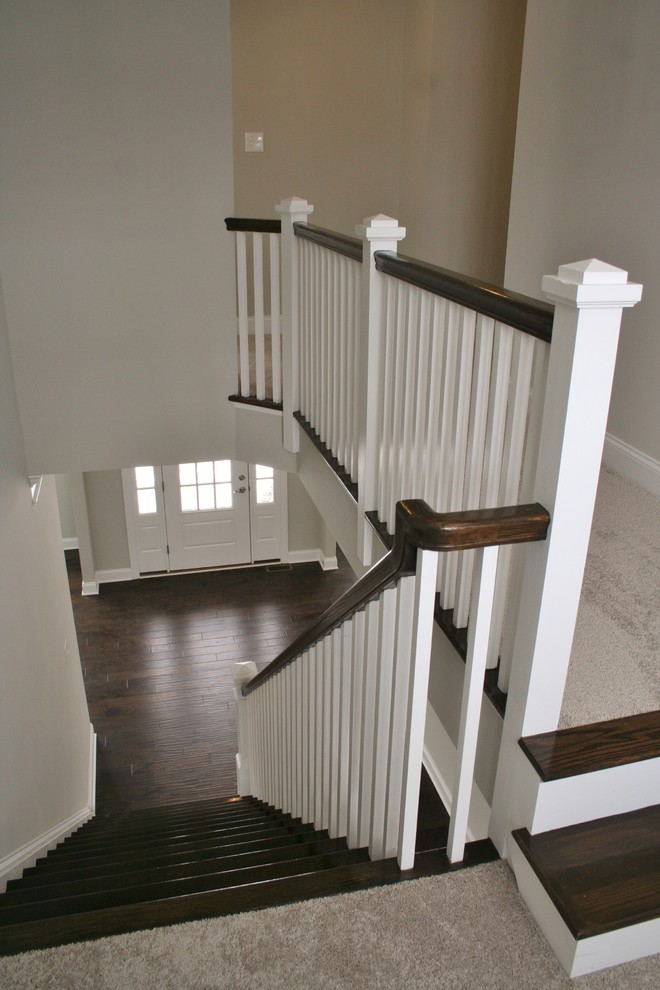 Cette image montre un escalier peint traditionnel en U avec des marches en bois.