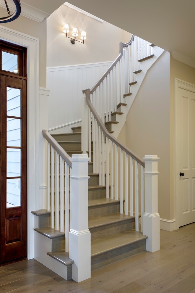 Источник вдохновения для домашнего уюта: изогнутая деревянная лестница среднего размера в классическом стиле с деревянными ступенями, деревянными перилами и панелями на стенах