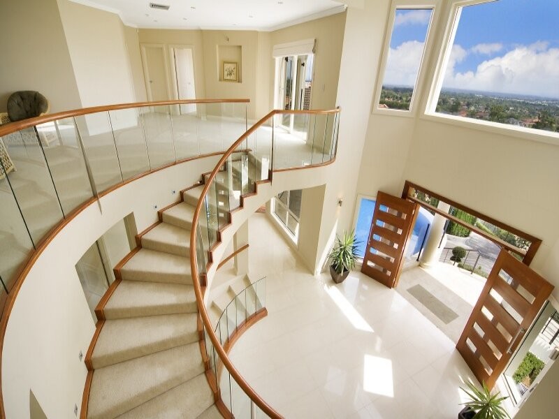Design ideas for a large contemporary carpeted curved glass railing staircase in Sydney with carpeted risers.