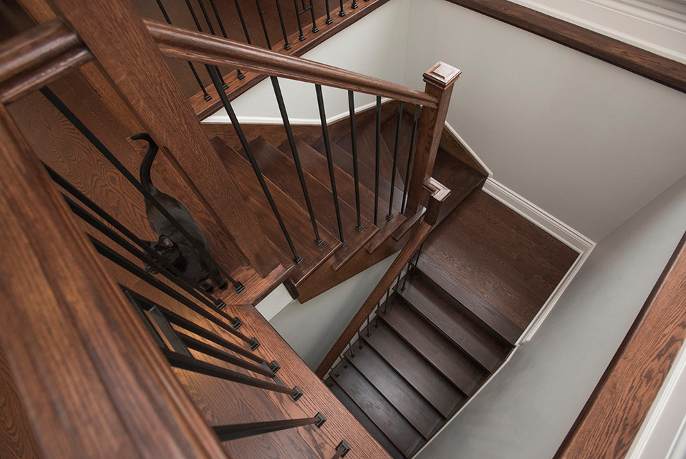На фото: большая п-образная деревянная лестница в классическом стиле с деревянными ступенями и металлическими перилами с