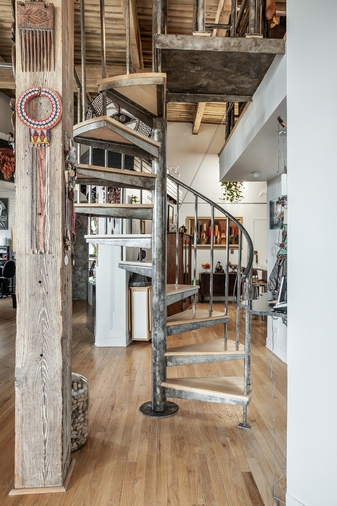 На фото: винтовая металлическая лестница среднего размера в стиле рустика с металлическими ступенями и металлическими перилами с