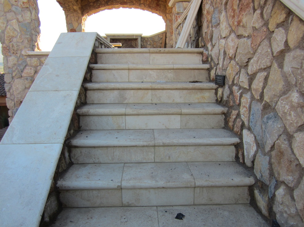 Idee per una scala a rampa dritta mediterranea di medie dimensioni con pedata in pietra calcarea e alzata in pietra calcarea