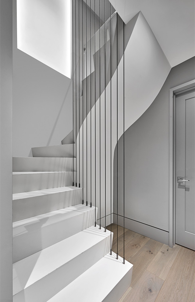 Стильный дизайн: маленькая изогнутая лестница в стиле модернизм с ступенями из плитки, подступенками из плитки и металлическими перилами для на участке и в саду - последний тренд