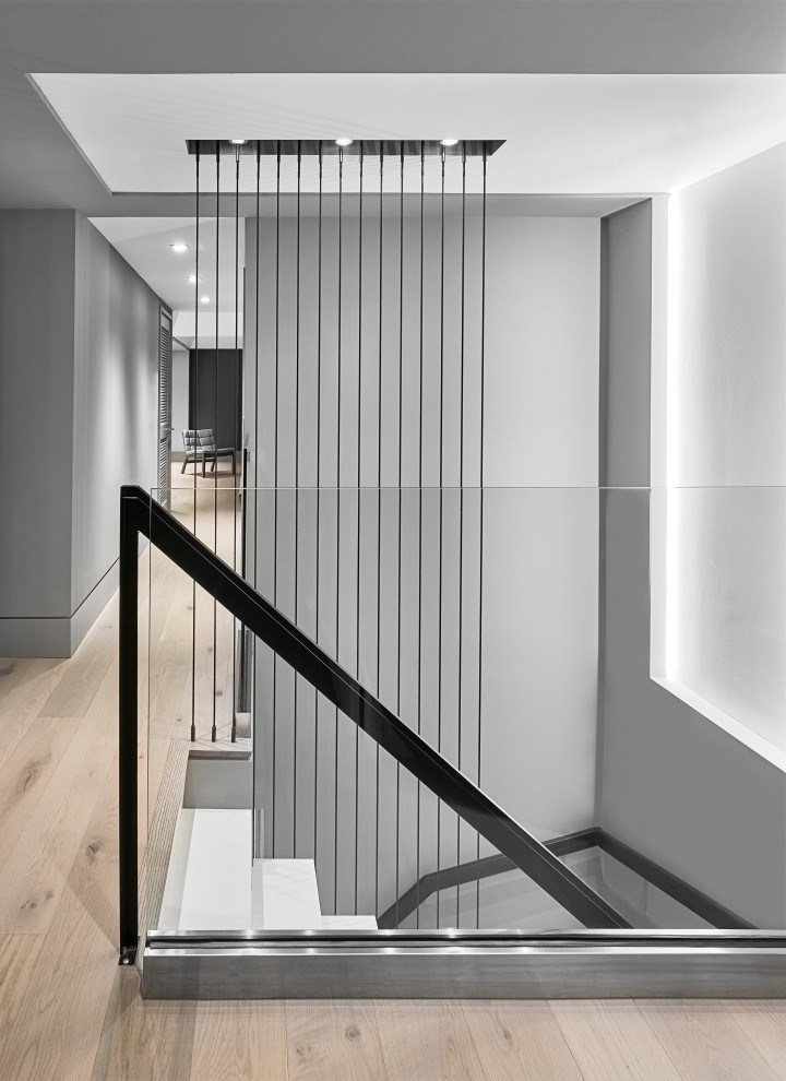 Gewendelte, Kleine Moderne Treppe mit gefliesten Treppenstufen, gefliesten Setzstufen und Stahlgeländer in Chicago