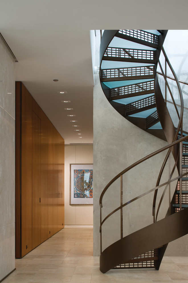 На фото: винтовая металлическая лестница в современном стиле с стеклянными ступенями с