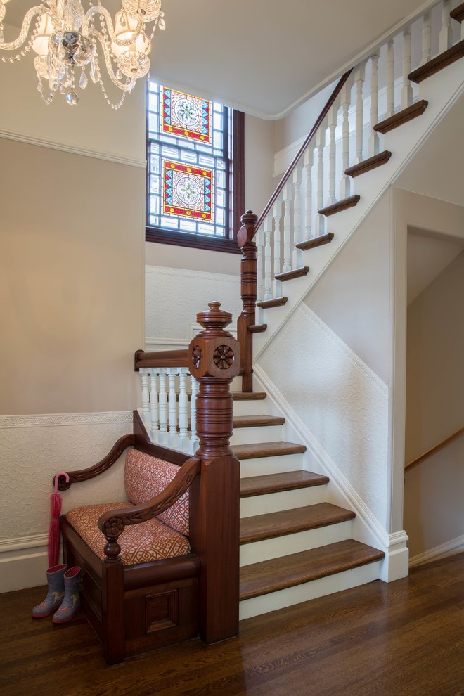 Diseño de escalera en U tradicional de tamaño medio con escalones de madera, contrahuellas de madera y barandilla de madera