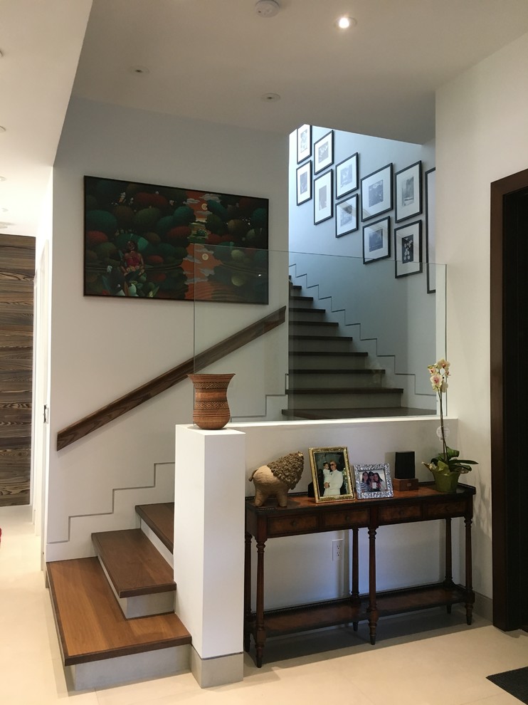 Cette photo montre un escalier tendance en L de taille moyenne avec des marches en bois, des contremarches en béton et un garde-corps en bois.