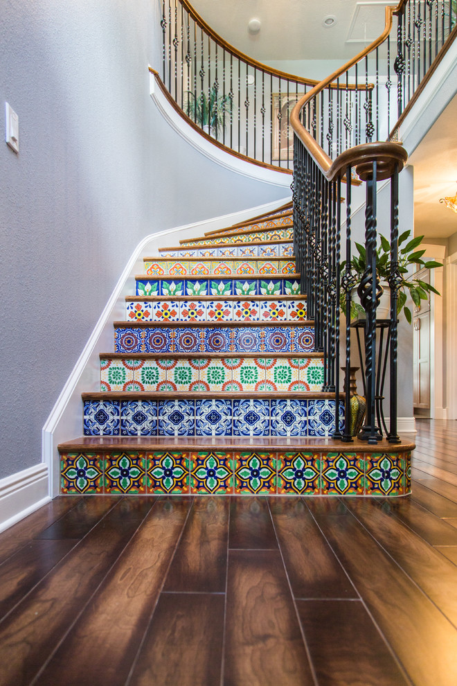 Diseño de escalera curva ecléctica grande con escalones de madera y contrahuellas con baldosas y/o azulejos