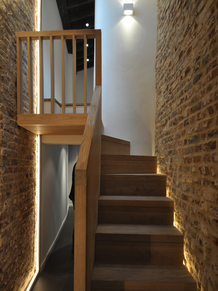 Small victorian wood l-shaped wood railing staircase in London with wood risers.
