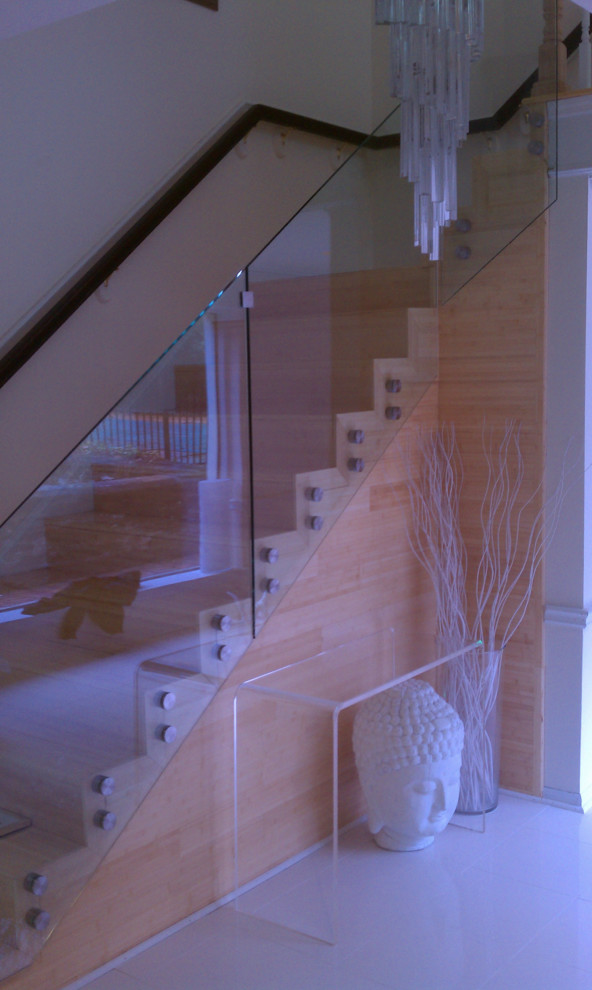 フィラデルフィアにある広いコンテンポラリースタイルのおしゃれなかね折れ階段 (木の蹴込み板、ガラスフェンス) の写真