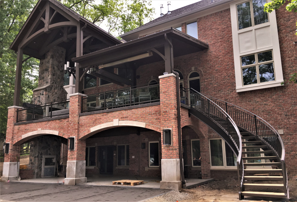 Gewendelte, Große Klassische Holztreppe mit offenen Setzstufen, Stahlgeländer und Ziegelwänden in Detroit