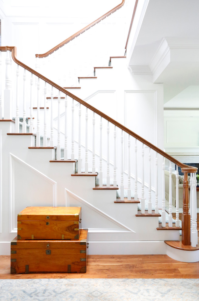 Ejemplo de escalera en L clásica renovada de tamaño medio con escalones enmoquetados, contrahuellas enmoquetadas y barandilla de madera