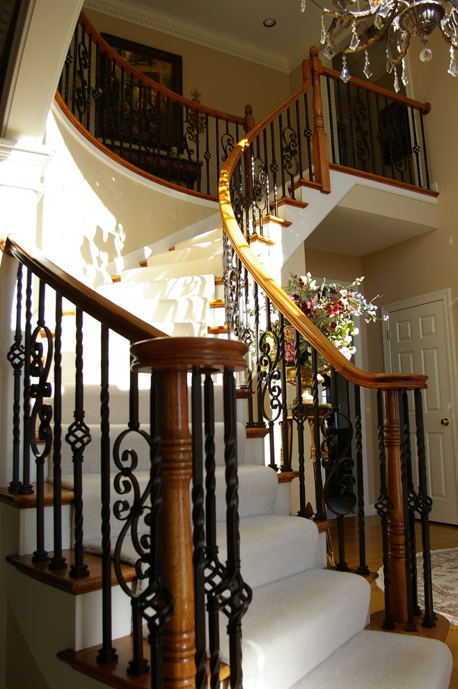 Aménagement d'un petit escalier courbe avec des marches en bois et des contremarches en moquette.